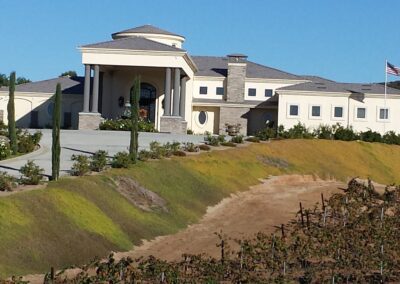 A large mansion sits on top of a hill in california.